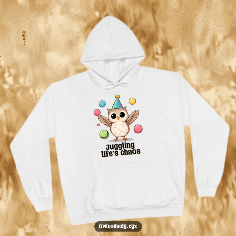 Funny hoodie displaying a delightful tiny owl wearing a party hat and juggling multiple colorful balls with its wings.